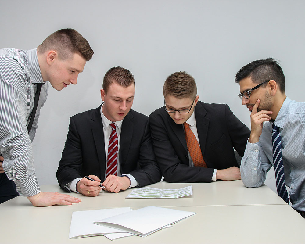 Image of a group of business men looking over paperwork